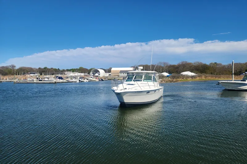 Slide: The Image of 2003 Tiara Yachts 3100 Open LE cruising in a serene marina setting. - 47