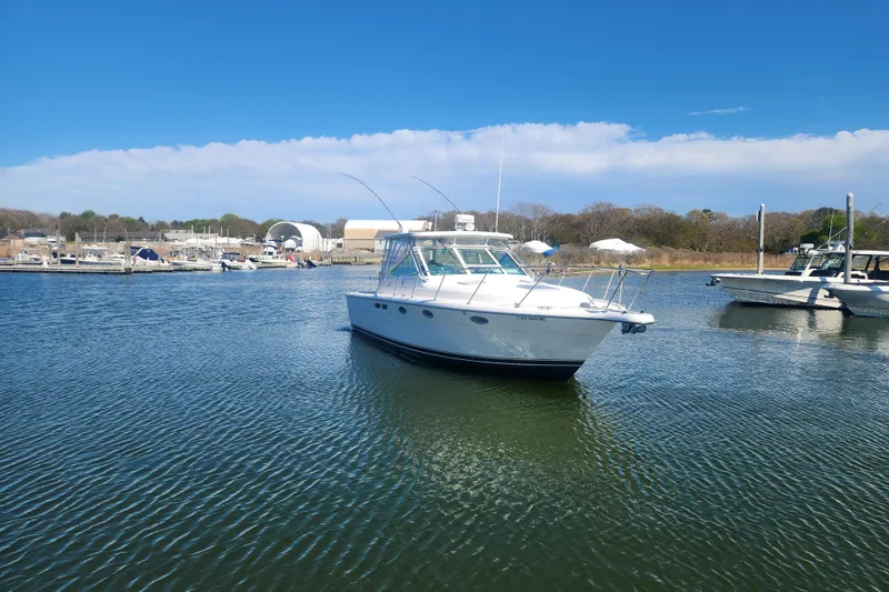 Slide: The Image of 2003 Tiara Yachts 3100 Open LE in a serene marina setting. - 49