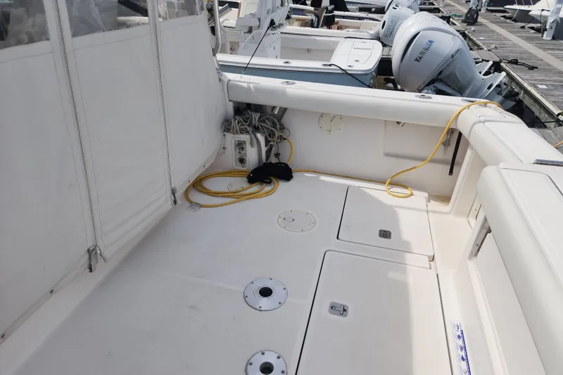 Slide: The Image of 2003 Tiara Yachts 3100 Open LE deck with storage compartments and docked boats. - 5