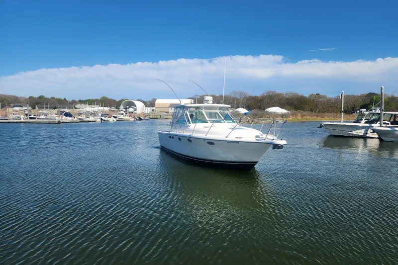 Slide: The Image of 2003 Tiara Yachts 3100 Open LE boat docked in a serene marina setting. - 50