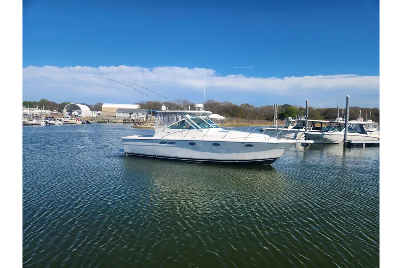 Slide: The Image of 2003 Tiara Yachts 3100 Open LE in a marina, under clear blue skies. - 52