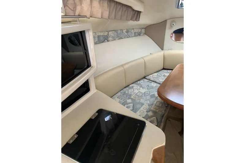 Slide: The Image of Interior of 2002 Chaparral Signature 260 boat with cozy seating and wooden table. - 10