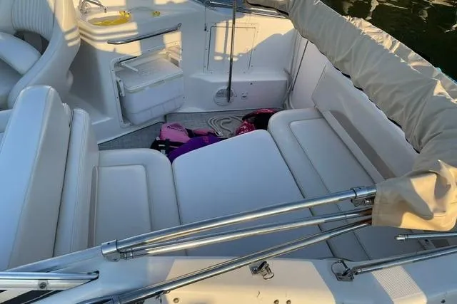 Slide: The Image of 2002 Chaparral Signature 260 boat interior with white seating and storage compartments. - 15