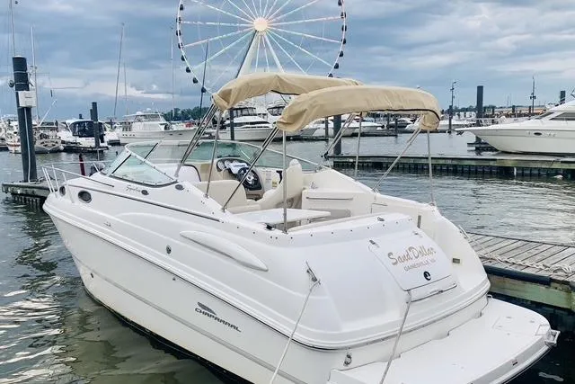 Slide: The Image of 2002 Chaparral Signature 260 boat docked at marina with Ferris wheel in background. - 2