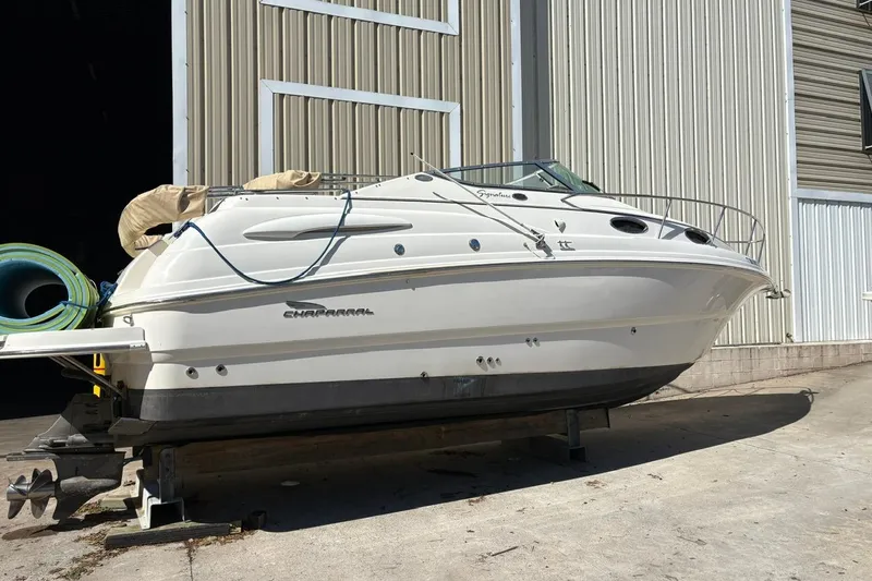 Slide: The Image of 2002 Chaparral Signature 260 boat on dry dock near a large metal building. - 4