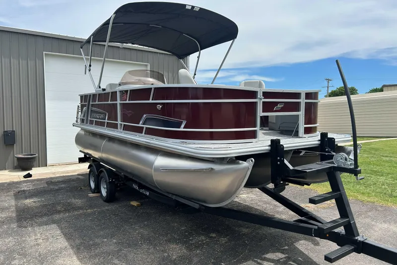 Slide: The Image of 2026 Starcraft EX 20 F pontoon boat on trailer, parked outdoors. - 11