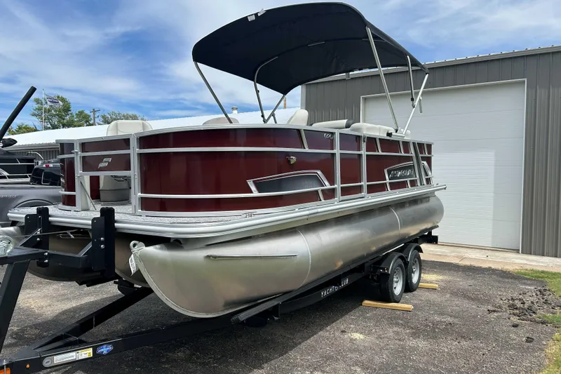 Slide: The Image of 2026 Starcraft EX 20 F pontoon boat on trailer, parked outdoors. - 9