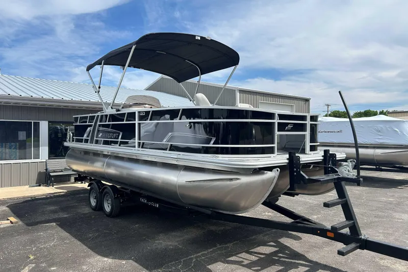 Slide: The Image of 2026 Starcraft EX 22 FD pontoon boat on trailer, parked outside a building. - 10