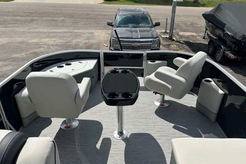 Slide: The Image of 2026 Starcraft EX 22 FD boat interior with seating and table, parked on a trailer. - 2
