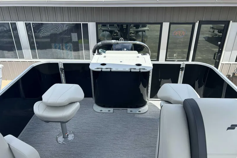 Slide: The Image of 2026 Starcraft EX 22 FD boat interior with seating and helm, docked near a building. - 4
