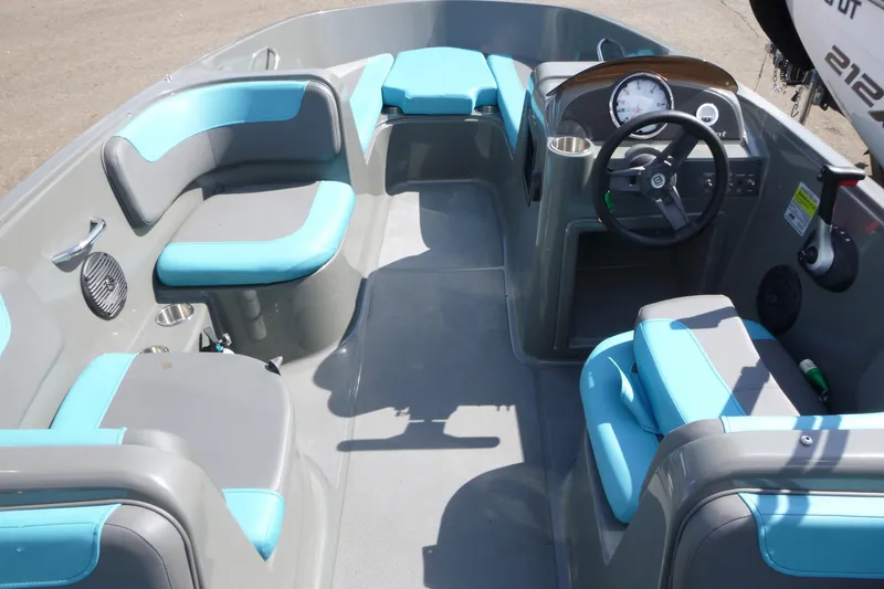 Slide: The Image of 2022 Bayliner Element E18 boat interior with blue and gray seating, steering wheel, and dashboard. - 5