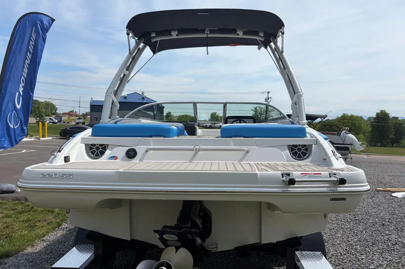Slide: The Image of 2025 Crownline 220 SS boat displayed outdoors with blue seating and canopy. - 2