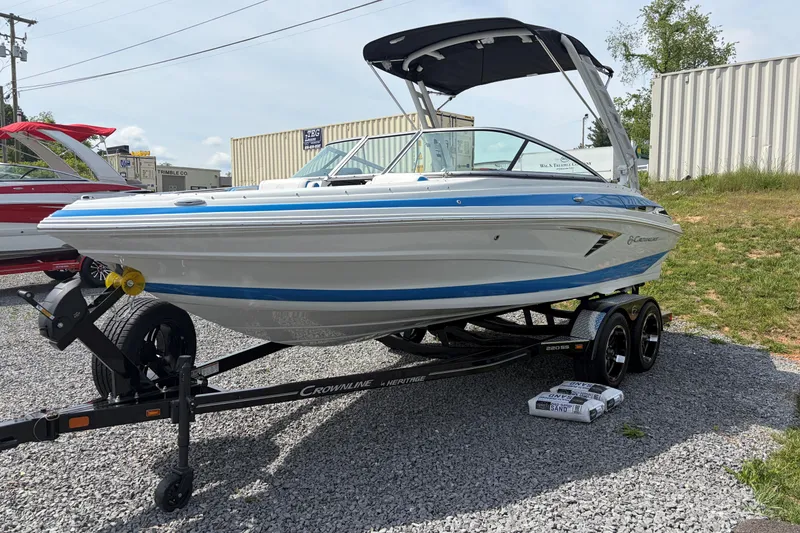 Slide: The Image of 2025 Crownline 220 SS boat on trailer, displayed outdoors. - 3