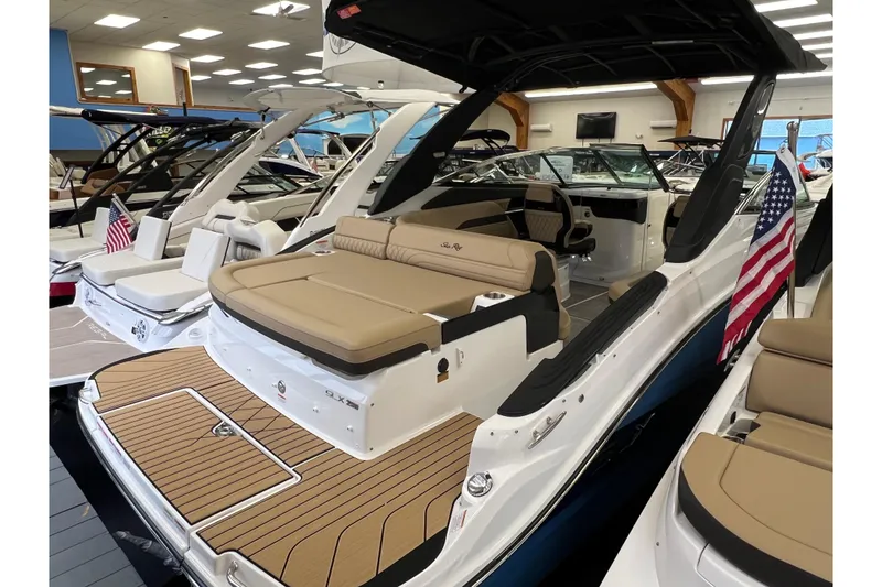 Slide: The Image of 2025 Sea Ray SLX 260 motorboat in showroom with American flag. - 2