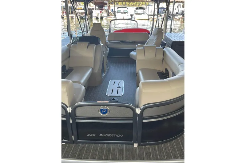 Slide: The Image of 2023 Premier Sunsation pontoon boat interior with beige seating and lake view. - 3