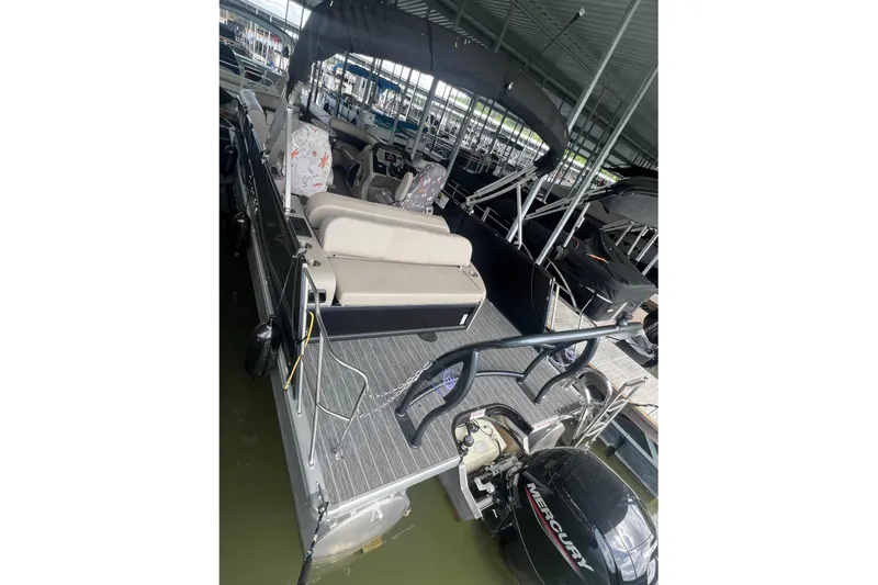 Slide: The Image of 2023 Premier Sunsation pontoon boat docked, featuring spacious seating and a Mercury outboard motor. - 6