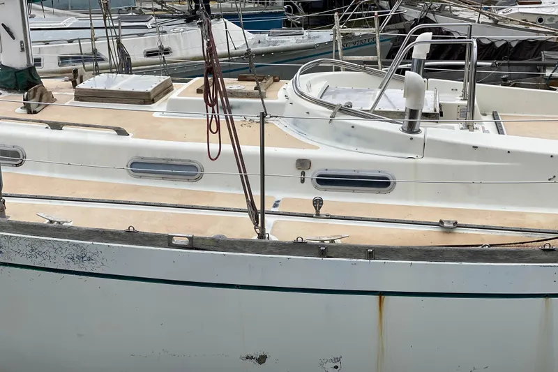 Slide: The Image of 1979 Fuji 40 sailboat docked, showing deck and cabin details. - 12