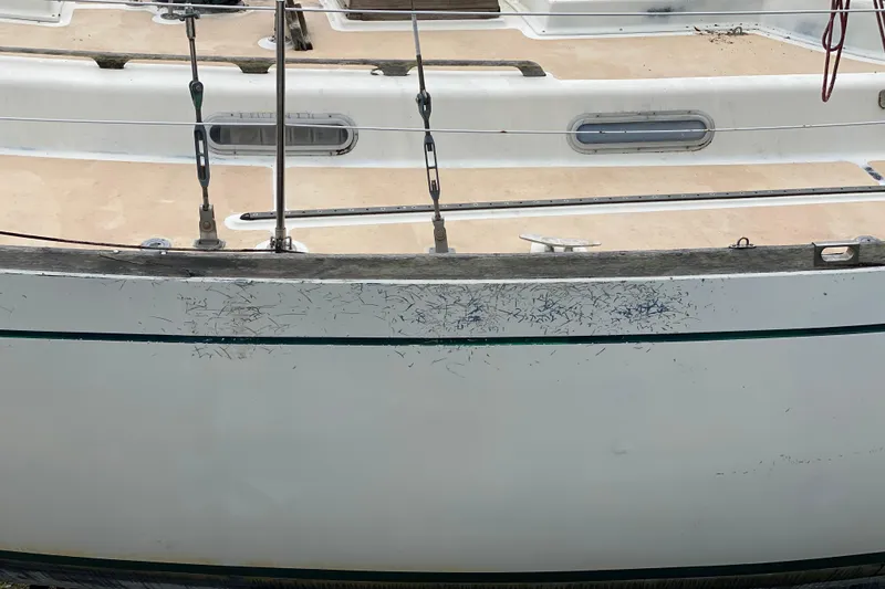 Slide: The Image of Side view of a 1979 Fuji 40 sailboat with visible scratches on the hull. - 14