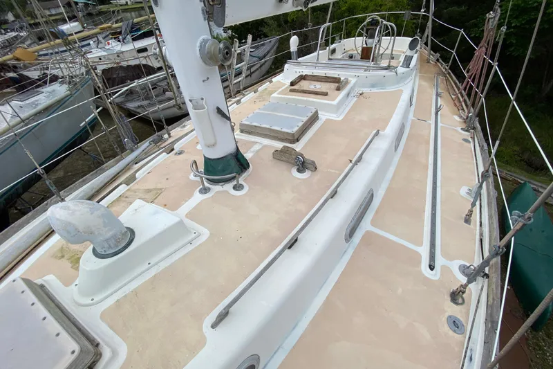Slide: The Image of 1979 Fuji 40 sailboat deck with mast and rigging, docked in a marina. - 26