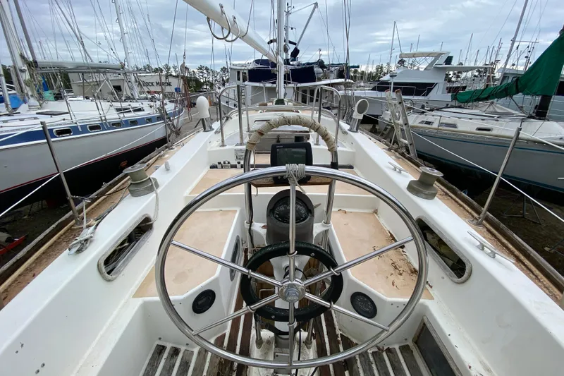 Slide: The Image of Cockpit view of a 1979 Fuji 40 sailboat in a marina, surrounded by other boats. - 34