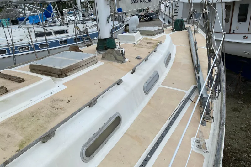 Slide: The Image of Deck of a 1979 Fuji 40 sailboat, showing hatches and rigging in a marina. - 38