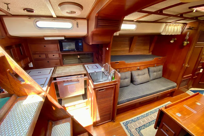 Slide: The Image of Interior of a 1979 Fuji 40 sailboat with wooden cabinetry and cozy seating area. - 40