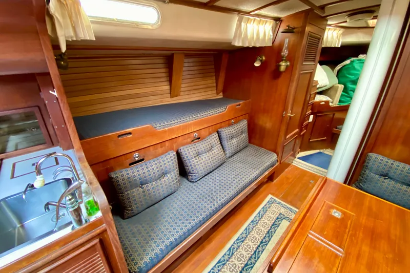 Slide: The Image of Interior of a 1979 Fuji 40 sailboat with wooden furnishings and cozy seating area. - 41