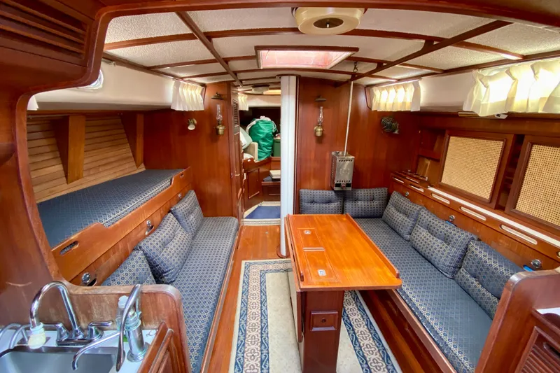Slide: The Image of Cozy interior of a 1979 Fuji 40 sailboat with wooden furnishings and blue cushions. - 42