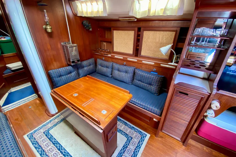 Slide: The Image of Cozy 1979 Fuji 40 yacht interior with wooden furnishings and blue cushioned seating. - 43