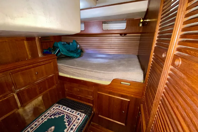 Slide: The Image of Cozy wooden cabin interior of a 1979 Fuji 40 sailboat with bed and storage. - 46
