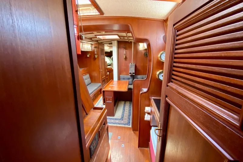 Slide: The Image of Interior of a 1979 Fuji 40 sailboat with rich wooden finishes and cozy seating. - 48
