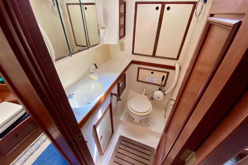 Slide: The Image of Compact 1979 Fuji 40 yacht bathroom with sink, toilet, and wooden cabinetry. - 51