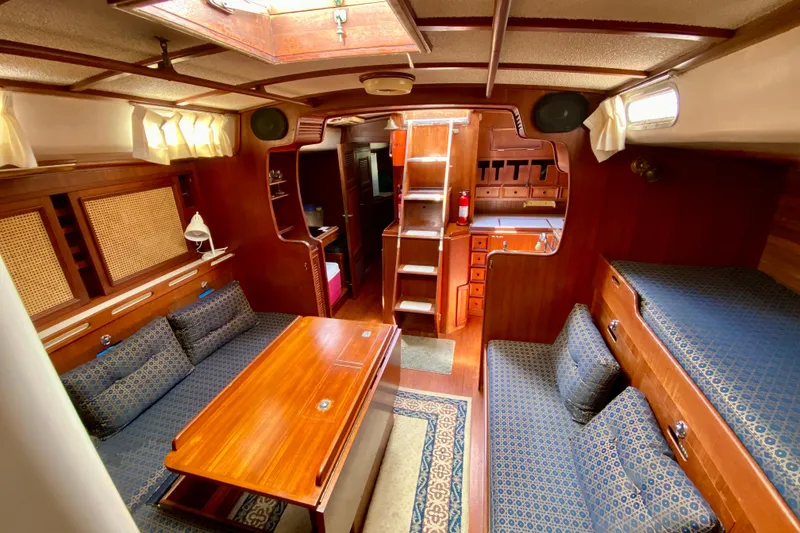 Slide: The Image of Cozy interior of a 1979 Fuji 40 sailboat with wooden furnishings and blue upholstery. - 55