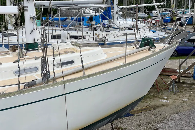 Slide: The Image of 1979 Fuji 40 sailboat in a boatyard, surrounded by other vessels. - 7