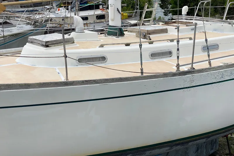 Slide: The Image of Sailboat deck of a 1979 Fuji 40, docked with visible railing and hatches. - 9