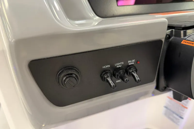 Slide: The Image of Control panel of 2025 Chaparral 21 SSi OB boat with switches for horn, lights, and bilge. - 14