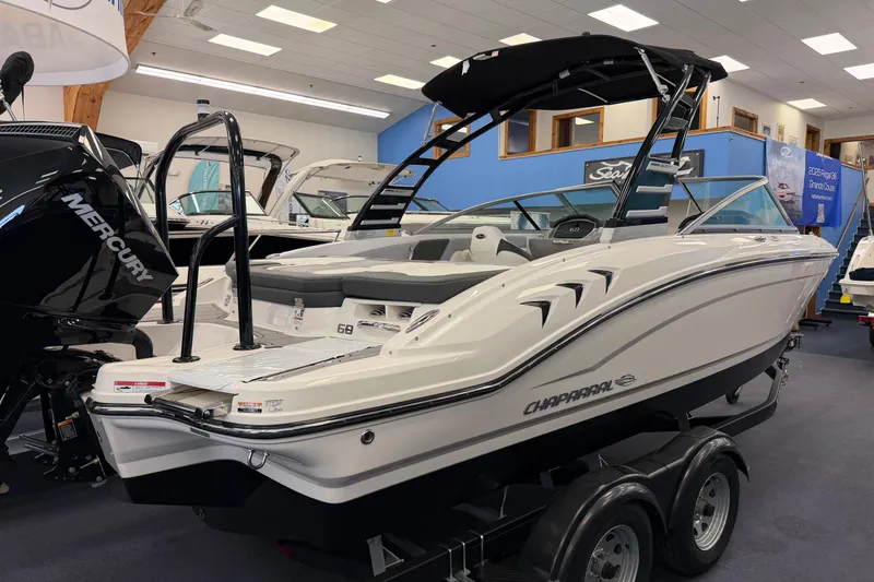 Slide: The Image of 2025 Chaparral 21 SSi OB boat displayed indoors on a trailer. - 2