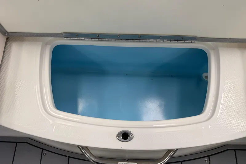 Slide: The Image of Livewell compartment in 2025 Chaparral 21 SSi OB boat, featuring a sleek white and blue design. - 8