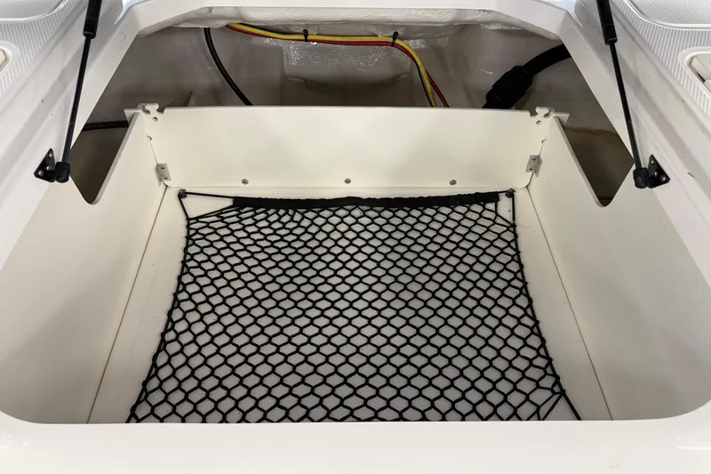 Slide: The Image of 2025 Chaparral 21 SSi OB storage compartment with netting and wiring. - 9