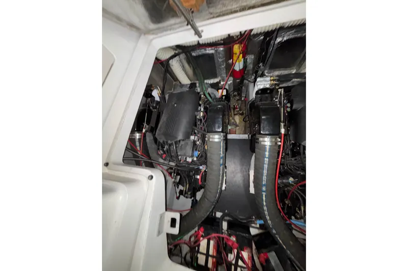 Slide: The Image of Engine compartment of a 1995 Luhrs 29 Open boat, showcasing dual engines and wiring. - 11