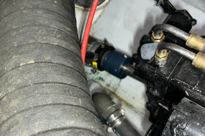 Slide: The Image of Engine compartment of a 1995 Luhrs 29 Open boat, showing hoses and mechanical components. - 14