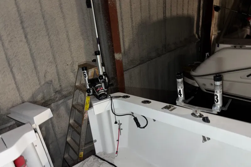 Slide: The Image of 1995 Luhrs 29 Open boat interior with fishing equipment and ladder in storage. - 19