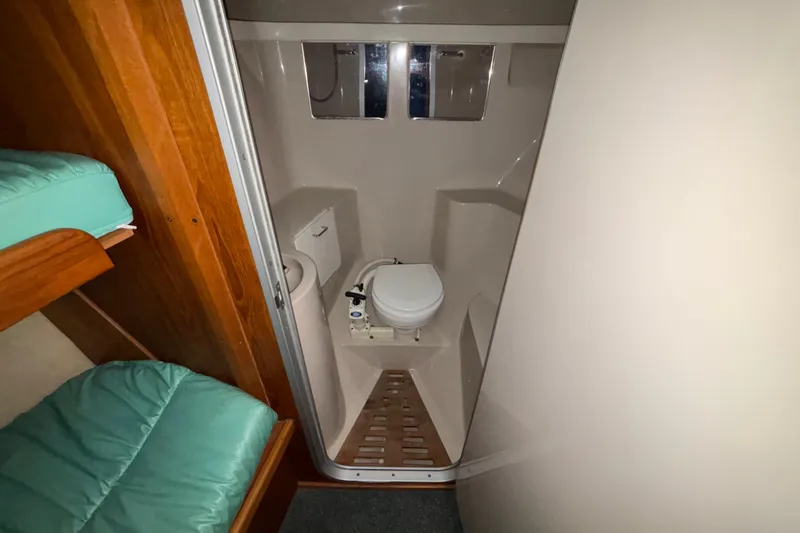 Slide: The Image of 1995 Luhrs 29 Open boat bathroom with compact toilet and wooden accents. - 28