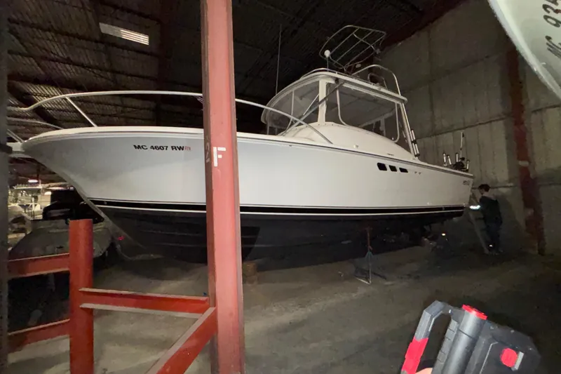 Slide: The Image of 1995 Luhrs 29 Open boat in storage, side view, indoors, with visible registration number. - 3