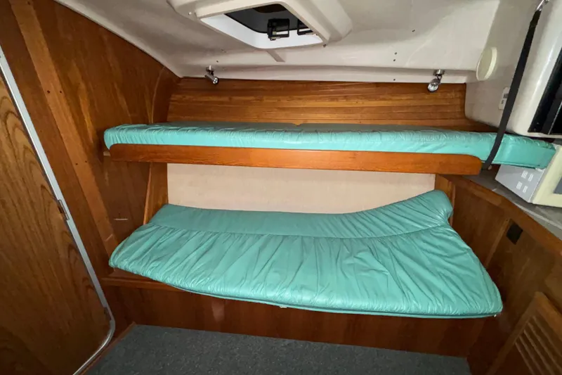 Slide: The Image of Interior cabin of 1995 Luhrs 29 Open boat with teal bunk beds. - 30