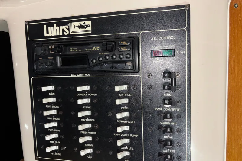 Slide: The Image of Control panel of a 1995 Luhrs 29 Open boat with switches and a JVC stereo. - 32