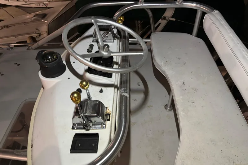 Slide: The Image of 1995 Luhrs 29 Open boat helm with steering wheel, throttle controls, and compass. - 36