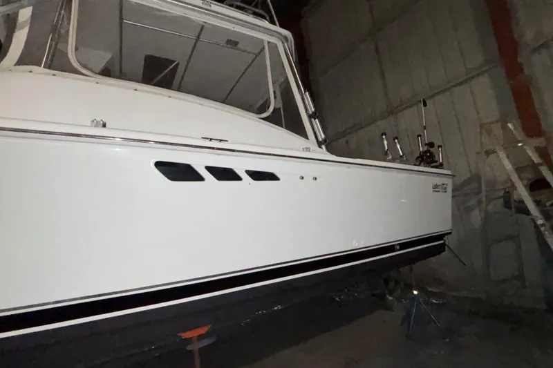 Slide: The Image of 1995 Luhrs 29 Open boat in storage, side view with fishing rod holders. - 4