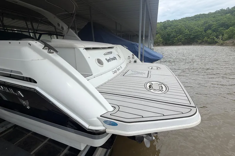 Slide: The Image of 2005 Formula 330 Sun Sport boat docked on a calm lake under a covered marina. - 2