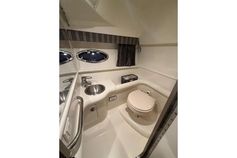 Slide: The Image of 2005 Formula 330 Sun Sport boat bathroom with sink, toilet, and porthole windows. - 30